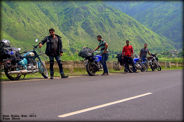 4 indian motorcyclists on tour in the spiti valley, stood by their motorcycles
